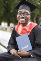 africano americano nel un' la laurea berretto con un' diploma. foto