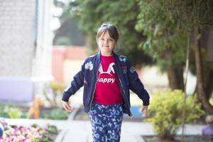 un' allegro ragazza a partire dal scuola materna giochi su il strada. foto