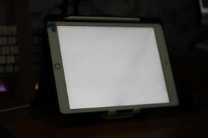 foto di un vuoto tavoletta con bianca schermo su il tavolo