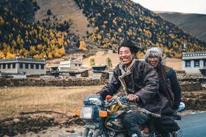 contento tibetano persone equitazione moto nel alto montagne foto