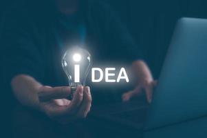 idea creatività concetto, uomo Tenere leggero lampadina con parola idea, ispirazione e innovazione nuovo tecnologia foto