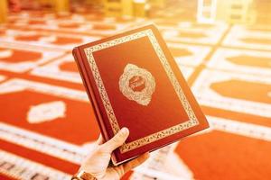 mano che tiene il Corano foto