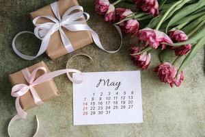 Maggio calendario, regalo scatole e tulipani mazzo foto