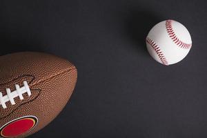 palla da rugby marrone e baseball su sfondo nero foto