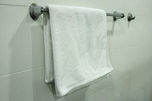 bianca bagno asciugamano sospeso su il bagno foto