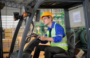 lavoratore nel auto parti magazzino uso un' carrello elevatore a forca per opera per portare il scatola di auto parti in il Conservazione mensola di il magazzino in attesa per consegna per il auto montaggio linea foto