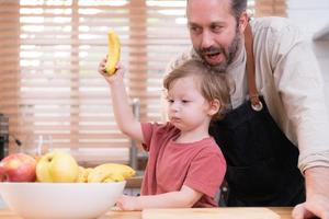 mamma e papà nel il cucina di il Casa con loro piccolo bambini. avere un' bene tempo fabbricazione cena insieme. foto