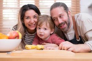 mamma e papà nel il cucina di il Casa con loro piccolo bambini. avere un' bene tempo fabbricazione cena insieme. foto