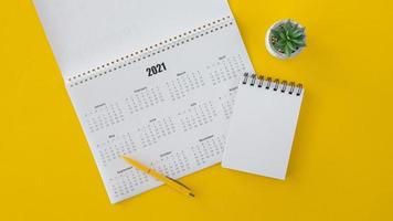 Calendario 2021 piatto laici con spazio di copia e blocco note su sfondo giallo