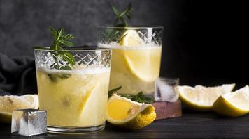 cocktail di bevande alcoliche con fettine di limone su sfondo scuro foto