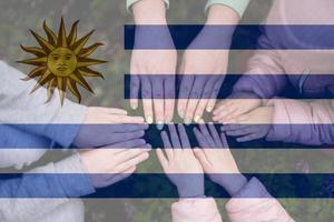 mani di bambini su sfondo di Uruguay bandiera. uruguaiano patriottismo e unità concetto. foto