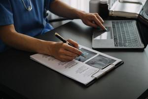 femmina medico indossare scrub nel ospedale corridoio utilizzando digitale tavoletta foto