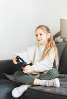 poco ragazza giocando su Giochi consolle foto