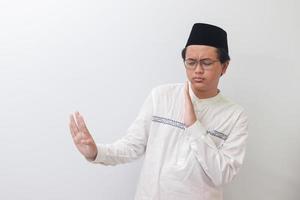 ritratto di giovane asiatico musulmano uomo formatura un' mano gesto per evitare qualcosa o cattivo le cose. isolato Immagine su bianca sfondo foto