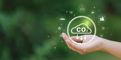 uomo d'affari Tenere co2 icona su virtuale schermo ridurre co2 emissioni per limite globale riscaldamento. inferiore co2 livelli con sostenibile foto