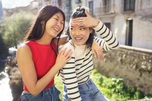 allegro asiatico amiche avendo divertimento insieme nel strada foto