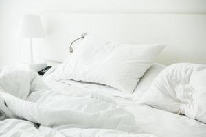 cuscino bianco sul letto sgualcito foto