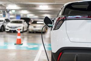 ricarica di elettrico macchine a un' ricarica stazione, settore automobilistico industria, mezzi di trasporto foto