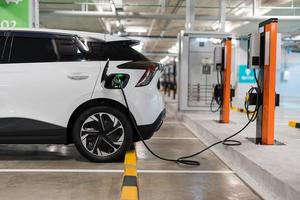 ricarica di elettrico macchine a un' ricarica stazione, settore automobilistico industria, mezzi di trasporto foto