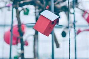 rosso di legno birdhouse sospeso su il filo foto