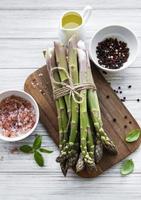 mazzo di gambi di asparagi crudi con spezie diverse foto