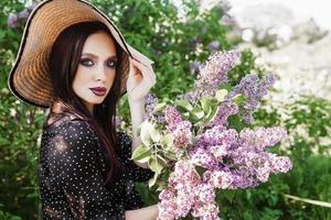 un' alla moda ragazza con buio capelli, un' primavera ritratto nel lilla toni nel estate. luminosa professionale trucco. foto