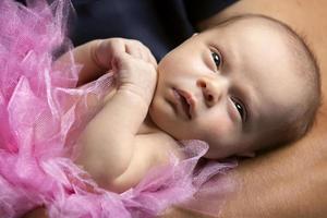 bellissimo calma neonato bambino ragazza con Aperto occhi. bambino vicino su. foto