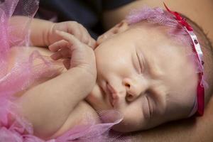 neonato bambino dormendo, piegare il armi.belle bambino con un' decorazione su sua testa. foto