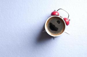 piatto creativo giaceva con una tazza di caffè e una sveglia. foto