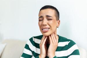 malato giorno a casa. giovane donna ha dolorante gola e Comune freddo. tosse. avvicinamento di bellissimo giovane donna catturato freddo o influenza malattia. ritratto di malsano ragazza con coronavirus, covid19 sintomi foto