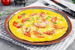 frittata con pomodori, erbe aromatiche e grattugiato formaggio. facile prima colazione foto