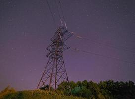 elettricità pilone contro notte cielo foto