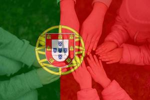mani di bambini su sfondo di Portogallo bandiera. portoghese patriottismo e unità concetto. foto