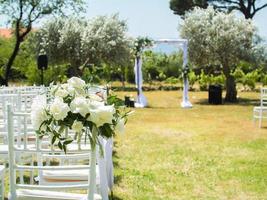 nozze arco decorato con stoffa e fiori all'aperto. bellissimo nozze impostato su. nozze cerimonia su verde prato nel il giardino. parte di il festivo arredamento e floreale disposizione. foto