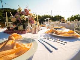 tavolo a lusso nozze ricezione evento. bellissimo fiori su tavolo e servendo piatti e bicchieri e decorazione foto