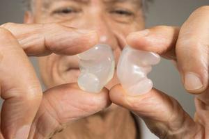 più vecchio uomo mostrando via il suo costume fatto silicone tappi per le orecchie per udito protezione foto