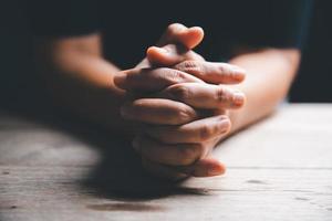 mani piegato nel preghiera su un' santo Bibbia nel Chiesa concetto per fede, spiritualità e religione, donna preghiere su santo Bibbia nel il mattina. donna mano con Bibbia pregando. foto