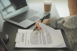 concetto di giustizia e diritto. il consulente legale presenta al cliente un contratto firmato con martelletto e diritto legale o una riunione del team legale presso uno studio legale in background foto