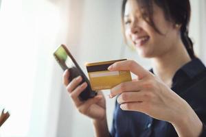 donna che immette informazioni sulla carta di credito sul suo telefono foto