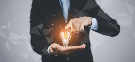 creatività nelle mani del concetto di idea di uomini d'affari, uomo d'affari che tiene una lampadina luminosa con cervello di disegno e linea di connessione, idee di pensiero creativo e innovazione, tecnologia e creatività foto