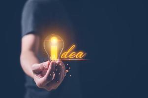 idea creatività concetto, uomo Tenere leggero lampadina con parola idea, ispirazione e innovazione nuovo tecnologia foto