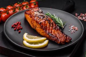 delizioso grigliato rosso salmone pesce con salsa, sesamo semi, spezie e erbe aromatiche foto