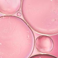 traslucido gocce di olio liquido liscio rosa sfondo sfocato foto