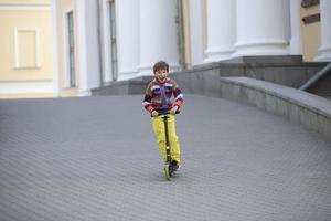 ragazzo contento su un' scooter nel un' città parco. foto