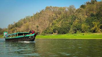 un' barca su il fiume con un' foresta nel il sfondo foto