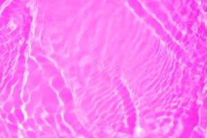 viola acqua con increspature su il superficie. defocus sfocato trasparente rosa colorato chiaro calma acqua superficie struttura con spruzzo e bolla. acqua onde con splendente modello struttura sfondo struttura foto