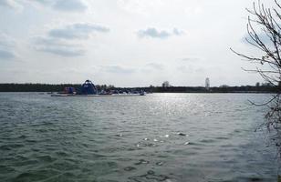 Basso angolo Visualizza di volontà lago parco con Locale e turista pubblico godendo il bellezza di lago e parco di a piedi in giro con loro famiglie. metraggio era catturato su 09-aprile-2023 a Milton keynes UK foto