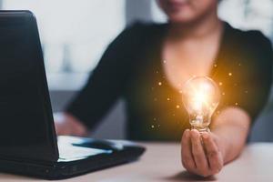 pensiero e creativo concetto, vicino su il leggero lampadina e donna Lavorando su il scrivania, creatività, e innovazione siamo chiavi per successo, nuovo idea e innovazione con cervello e leggero lampadine, foto