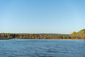 paesaggio naturale con un lago e alberi d'autunno sulla riva. foto