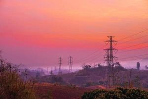 pali dell'elettricità e paesaggio la sera al tramonto foto